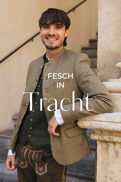 Ein lächelnder Mann in traditioneller deutscher Kleidung (Tracht) steht an einem steinernen Geländer; der Text lautet "Fesch in Tracht.