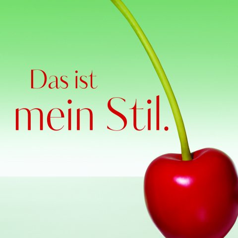 Im Vordergrund ist eine rote Kirsche mit langem Stiel vor einem grünen Hintergrund mit Farbverlauf zu sehen. Links steht in rotem Text „Das ist mein Stil.“