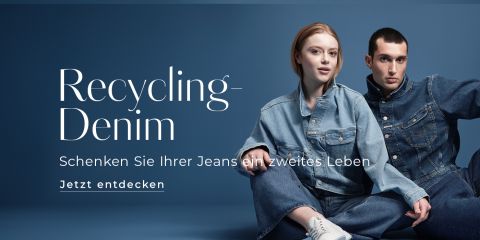 Eine Frau und ein Mann in Jeanskleidung posieren vor blauem Hintergrund. Der Text auf der linken Seite lautet: „Recycling-Denim. Schenken Sie Ihrer Jeans ein zweites Leben. Jetzt entdecken.“.