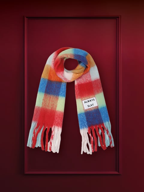 Eine hölzerne Pfeffermühle auf dunkelrotem Hintergrund. Auf dem Korpus der Mühle ist ein Text eingraviert. Oben im Bild steht der Satz „NACHHALTIGE GESCHENKE“.