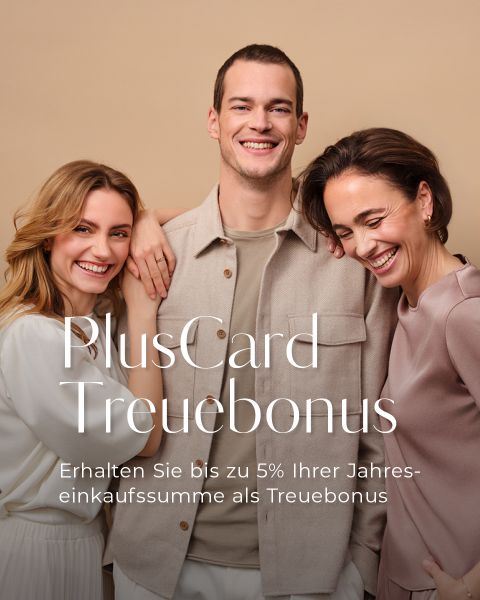 Drei lächelnde Erwachsene stehen dicht beieinander vor einem beigen Hintergrund. Weißer Text in deutscher Sprache wirbt für einen PlusCard-Treuebonus, der bis zu 5 % des Jahreseinkaufs als Belohnung bietet.