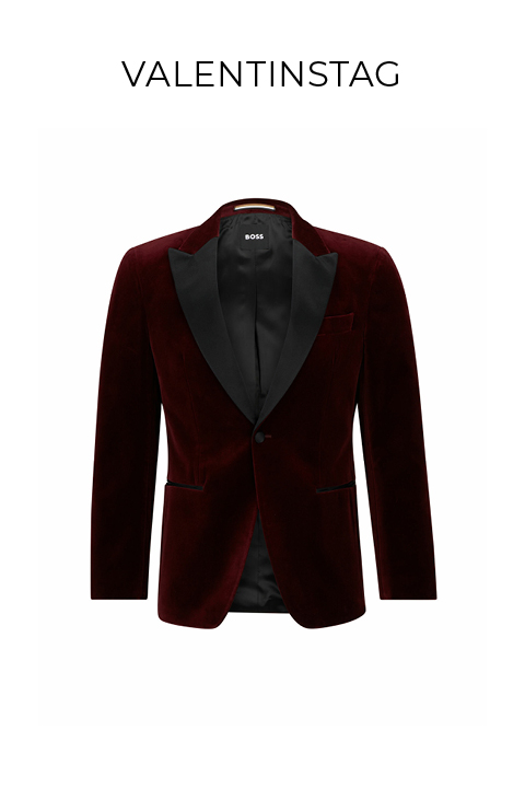 Ein eleganter Blazer aus burgunderfarbenem Samt mit schwarzen Satin-Revers vor weißem Hintergrund. Über dem Blazer ist das Wort „VALENTINSTAG“ zu sehen.