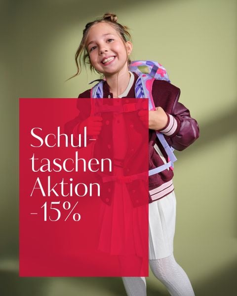 Ein lächelndes Mädchen mit einem Rucksack steht vor einem grünen Hintergrund. Text: "Schultaschen Aktion -15% auf Schultaschen & Sets.