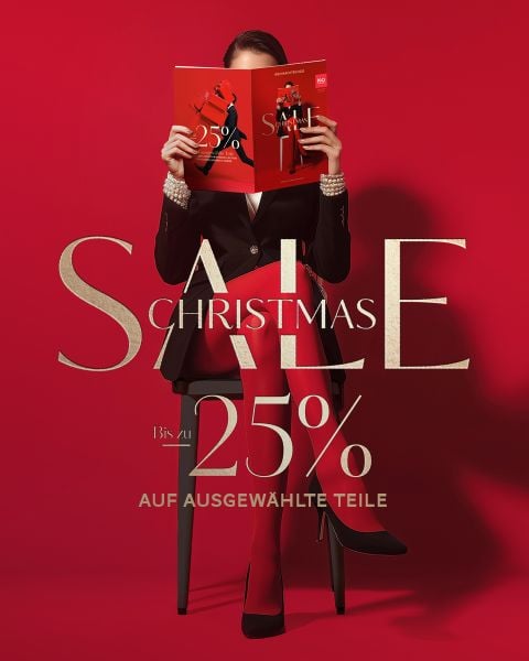 Eine Frau in Rot sitzt auf einem Stuhl und hält eine rote Zeitschrift in der Hand; der Text lautet "Christmas Sale bis zu 25% auf ausgewählte Teile" auf rotem Hintergrund.